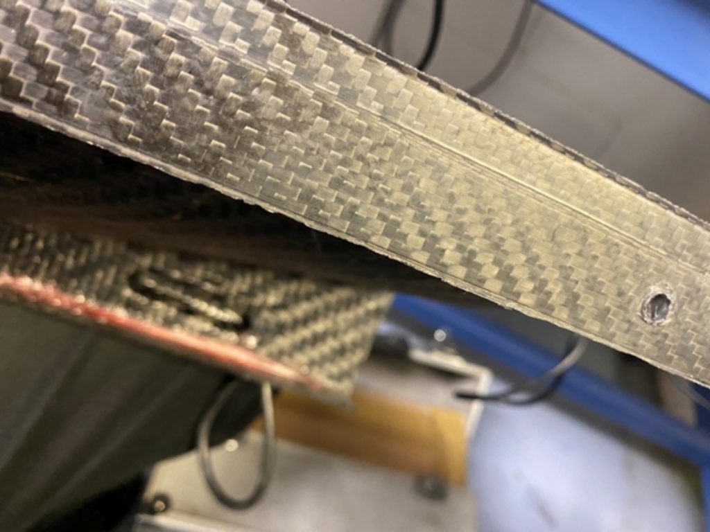 Composite edge before deburring with visible roughness and edge burrs