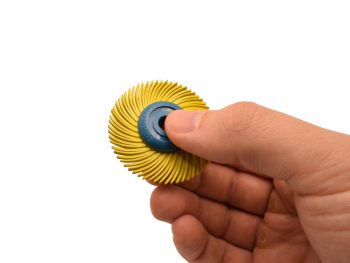 Yellow 80 grit Dedeco Sunburst 2 inch TC 3-ply radial wheel held in hand for scale