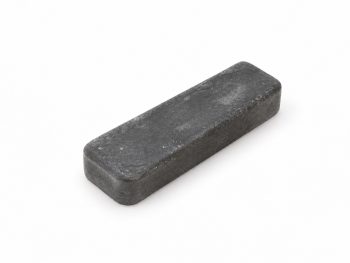 Small 4 x 1 inch black Abramax polishing compound bar on a white background.