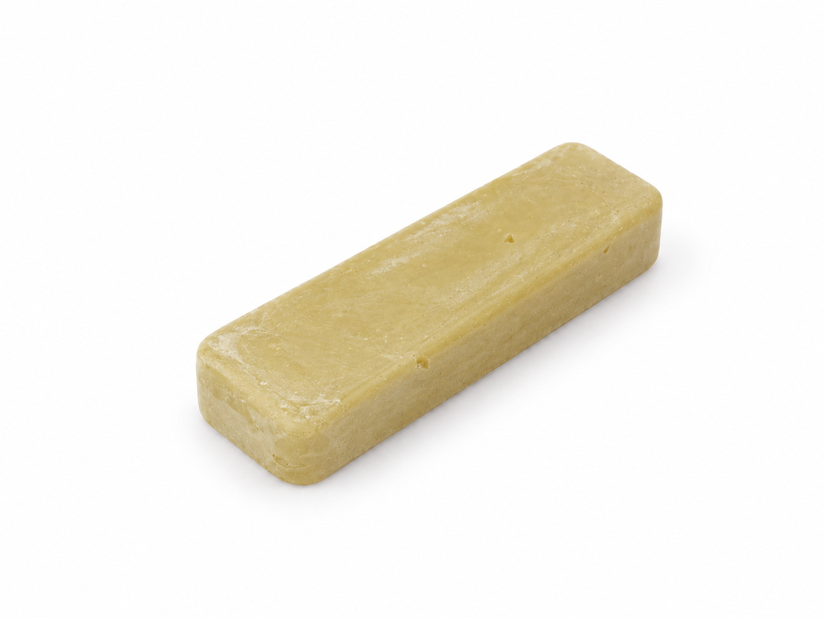Small 4 x 1 inch buff Plastimax polishing compound bar on a white background.